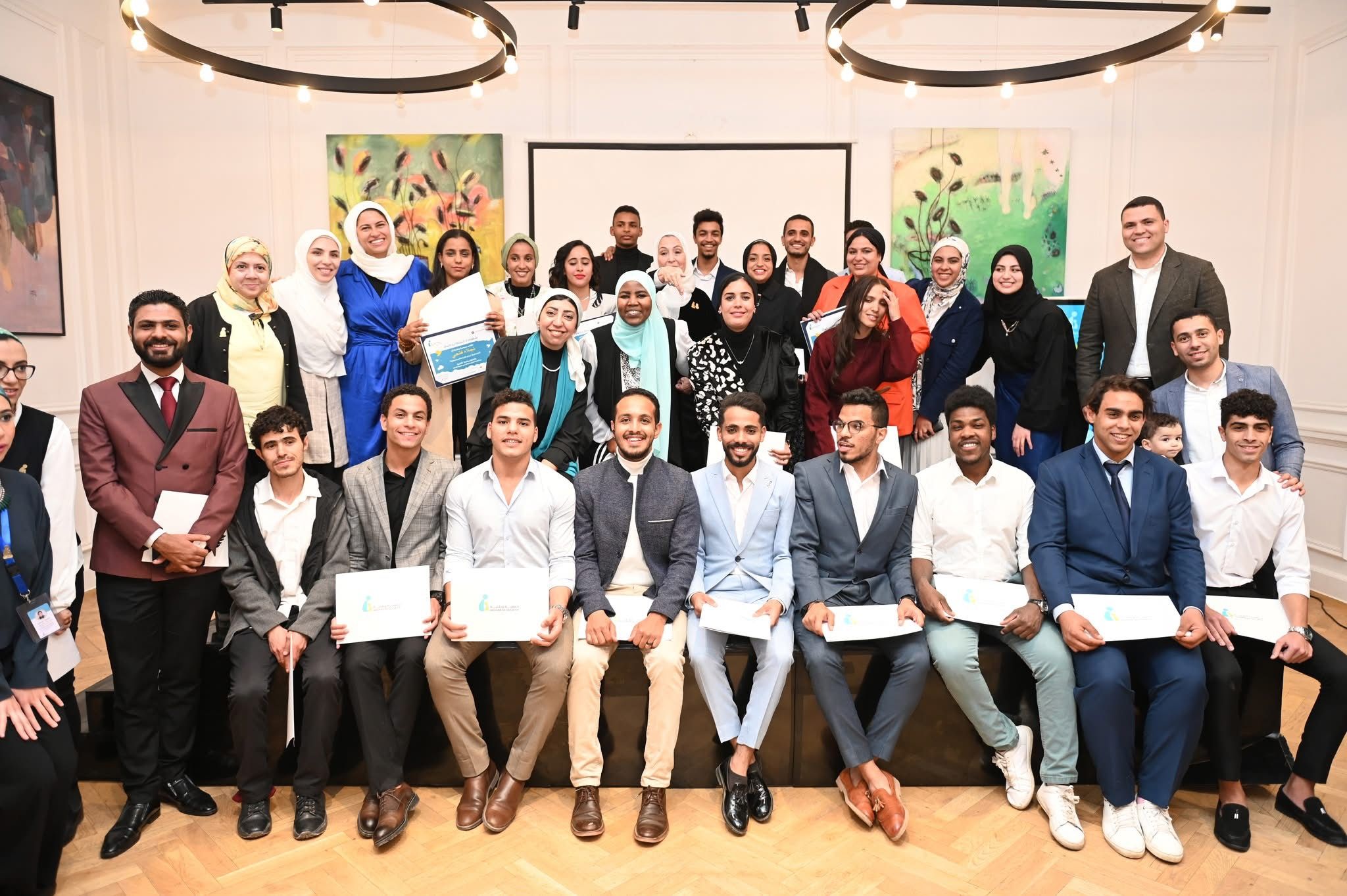 صورة جماعية للمشاركين وهم يحملون شهادات