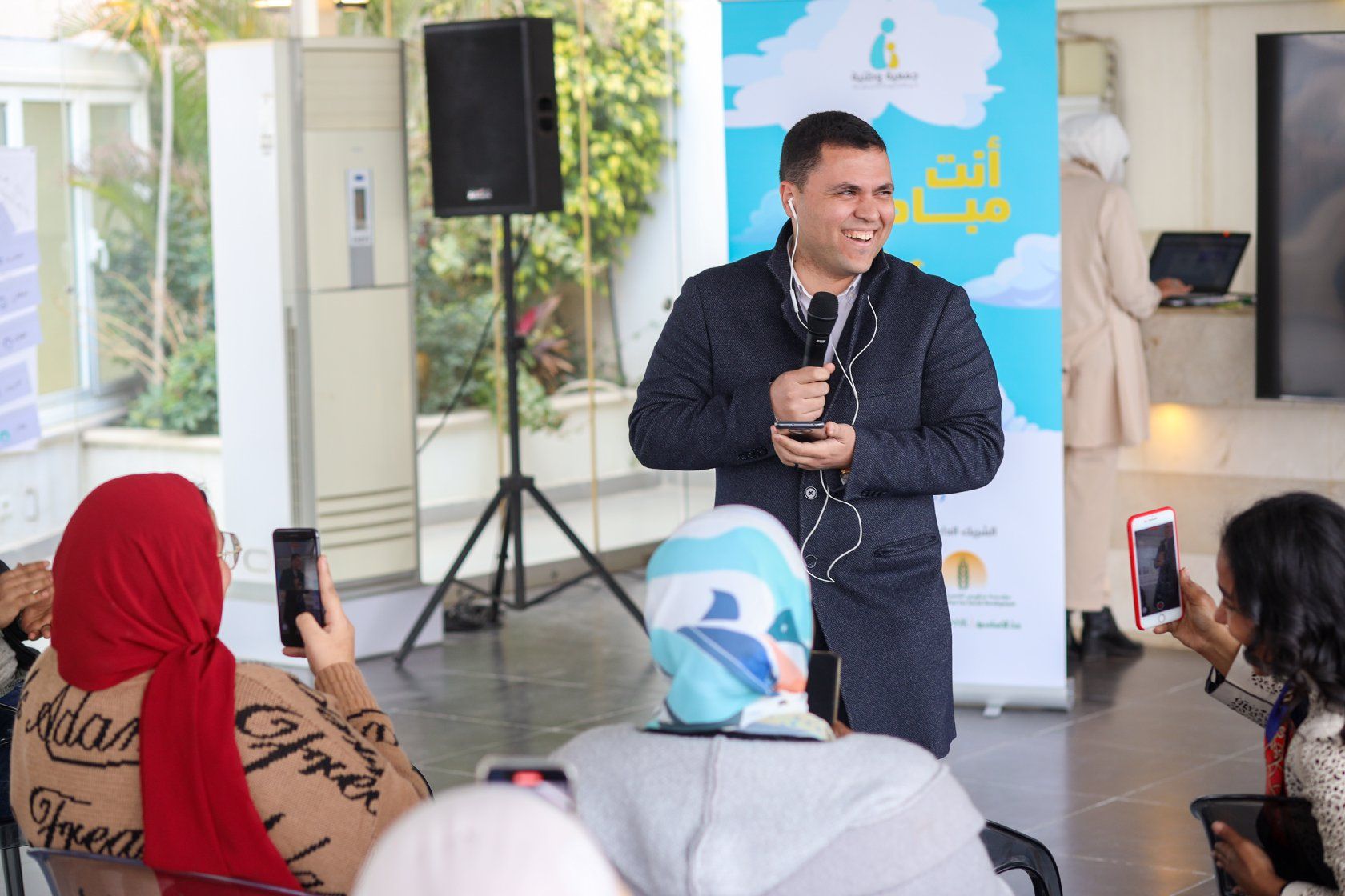متحدث يحمل الميكروفون أمام خلفية ملونة